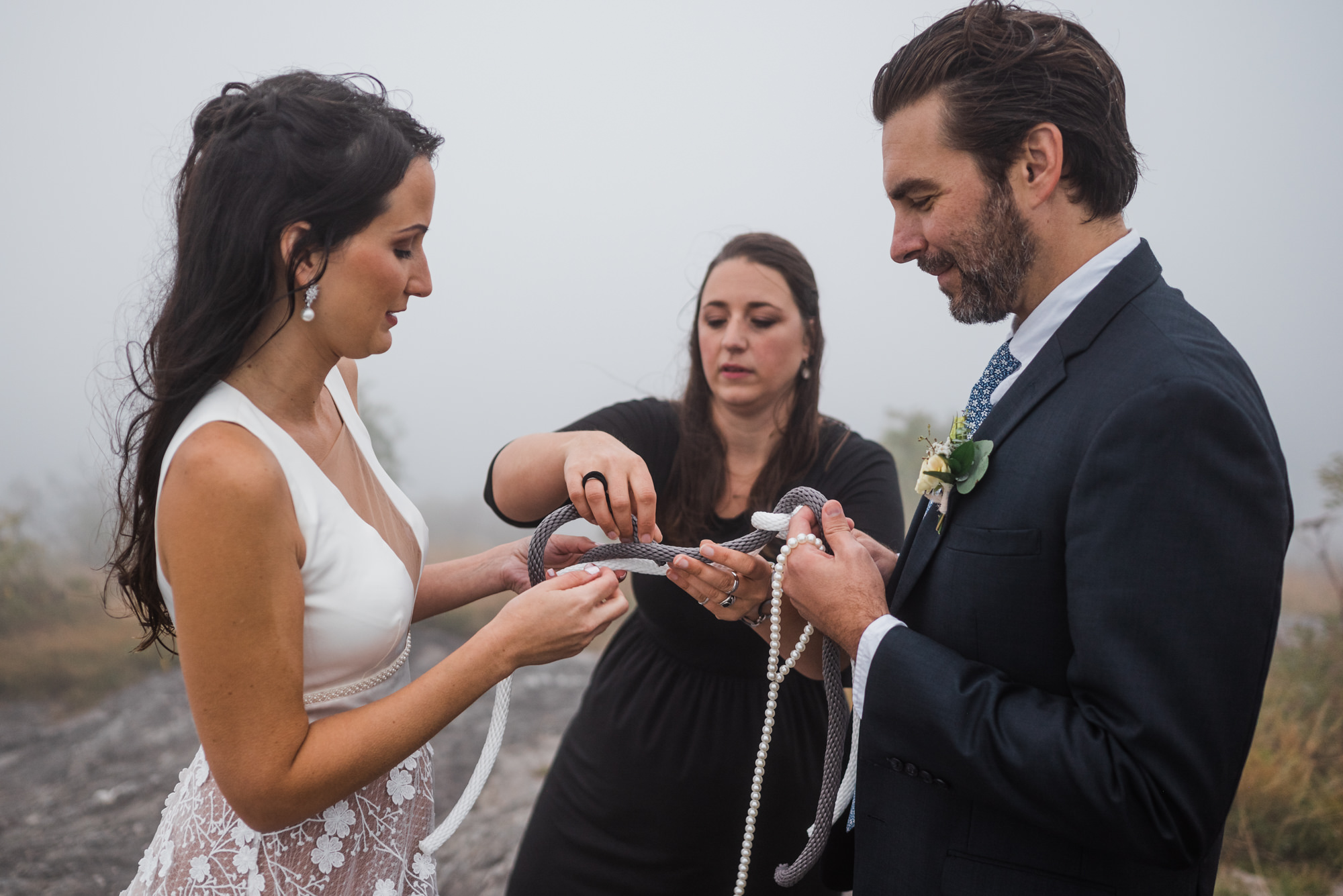 Couple doing a knot-tying ritual during their mountain elopement