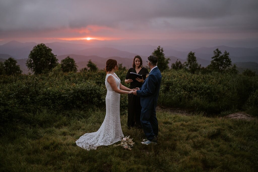 Couple eloping in the mountains near Asheville, NC with their officiant at sunrise.